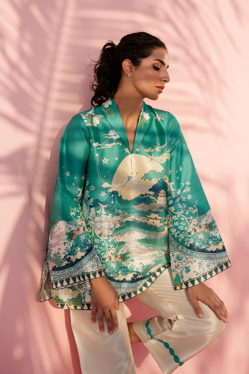 Woman wearing a teal kimono-style outfit with white patterns against a pink background