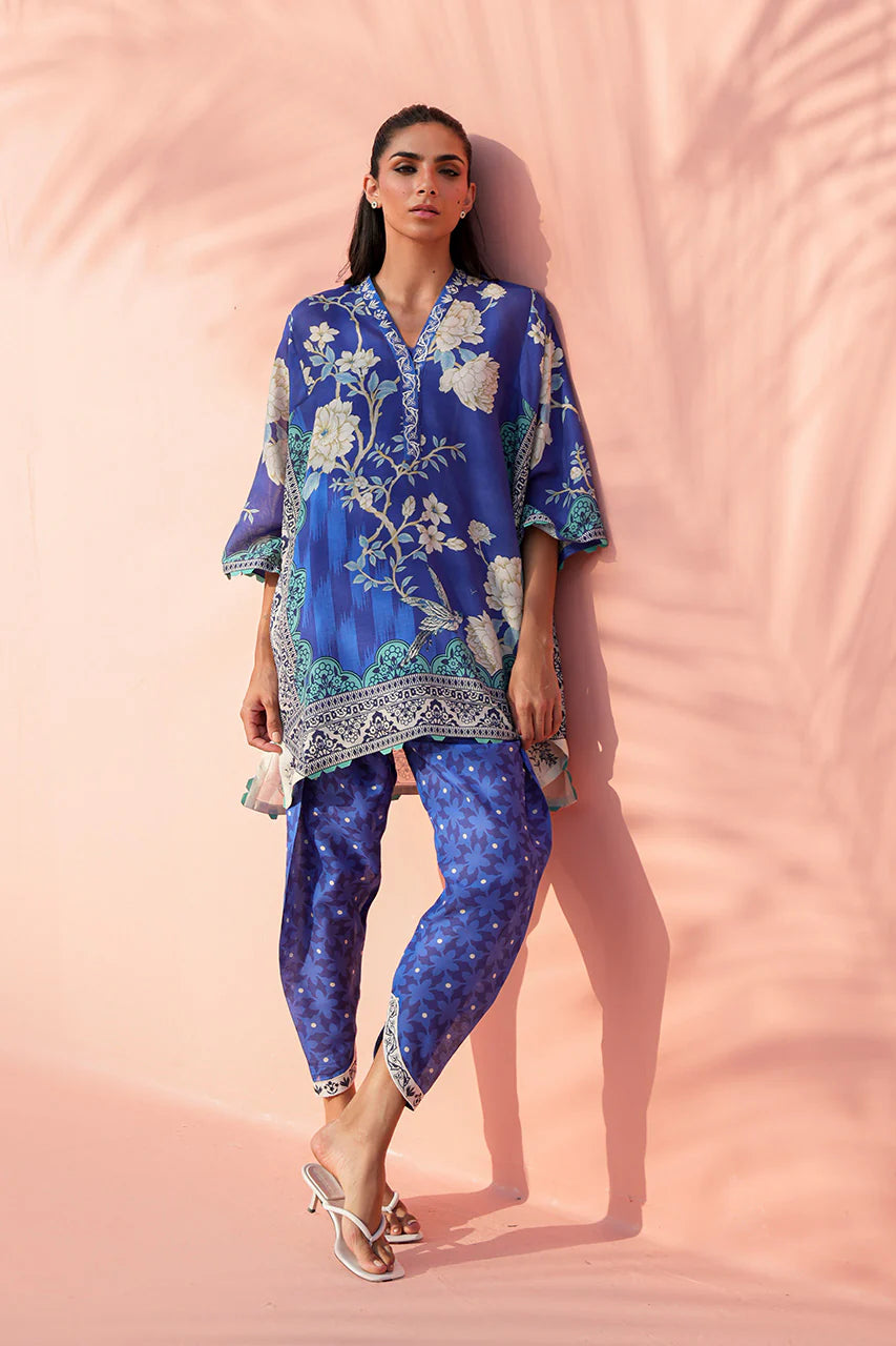 Woman wearing a blue floral outfit against a pink background