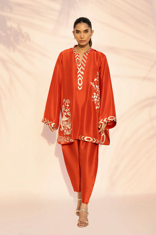 Woman wearing an orange outfit with intricate white patterns on a beige background