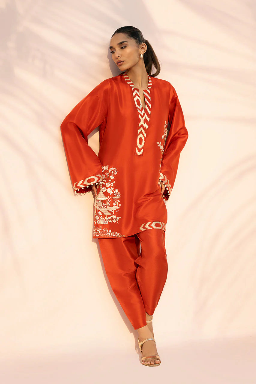 Woman wearing a red traditional outfit with white patterns on a light pink background
