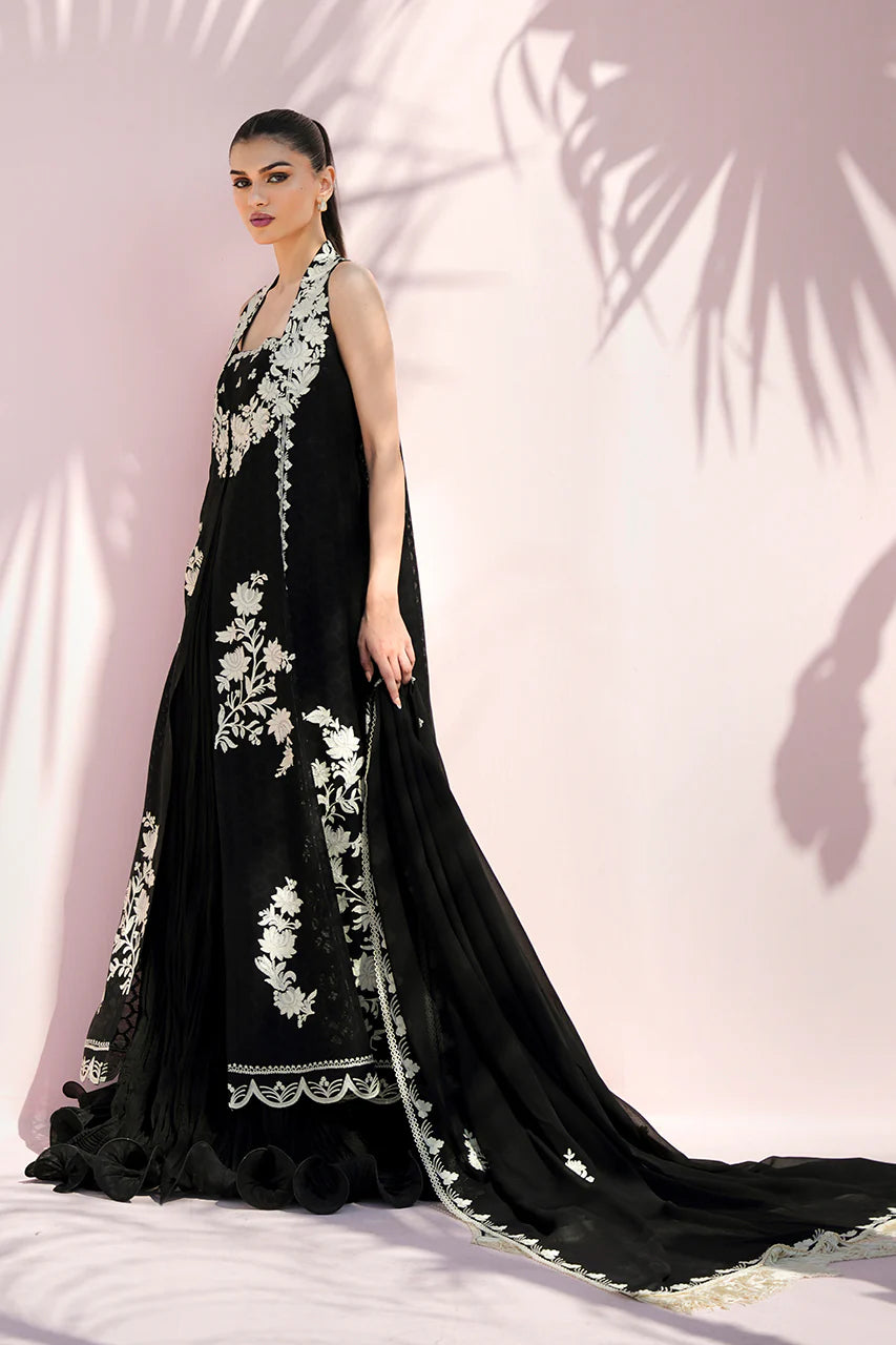 Black evening gown with white floral embroidery on a pink background
