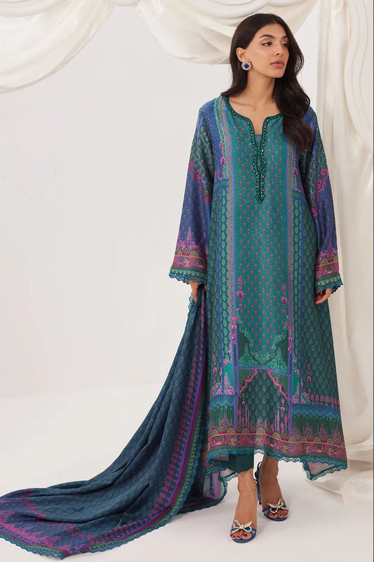 Woman wearing a blue and green embroidered traditional outfit with a white background