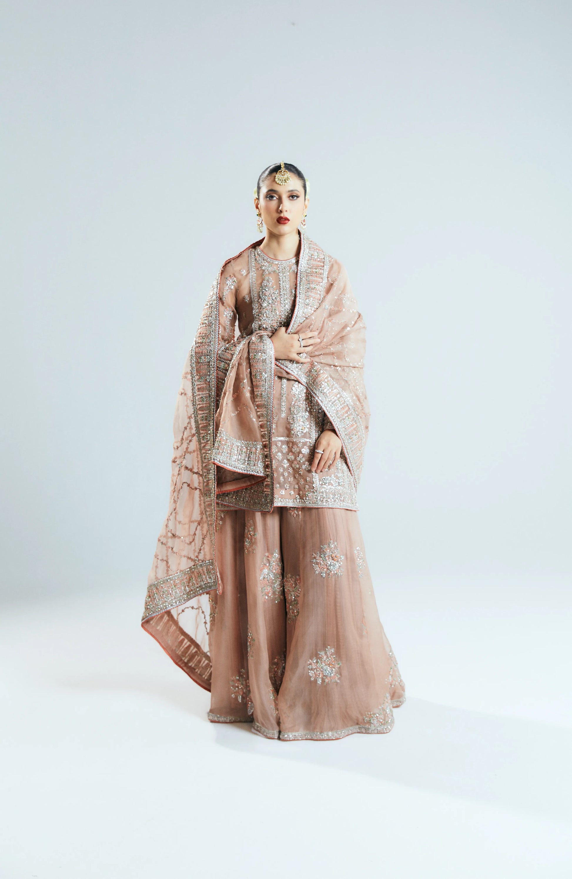 Woman wearing a traditional outfit with a shawl on a white background