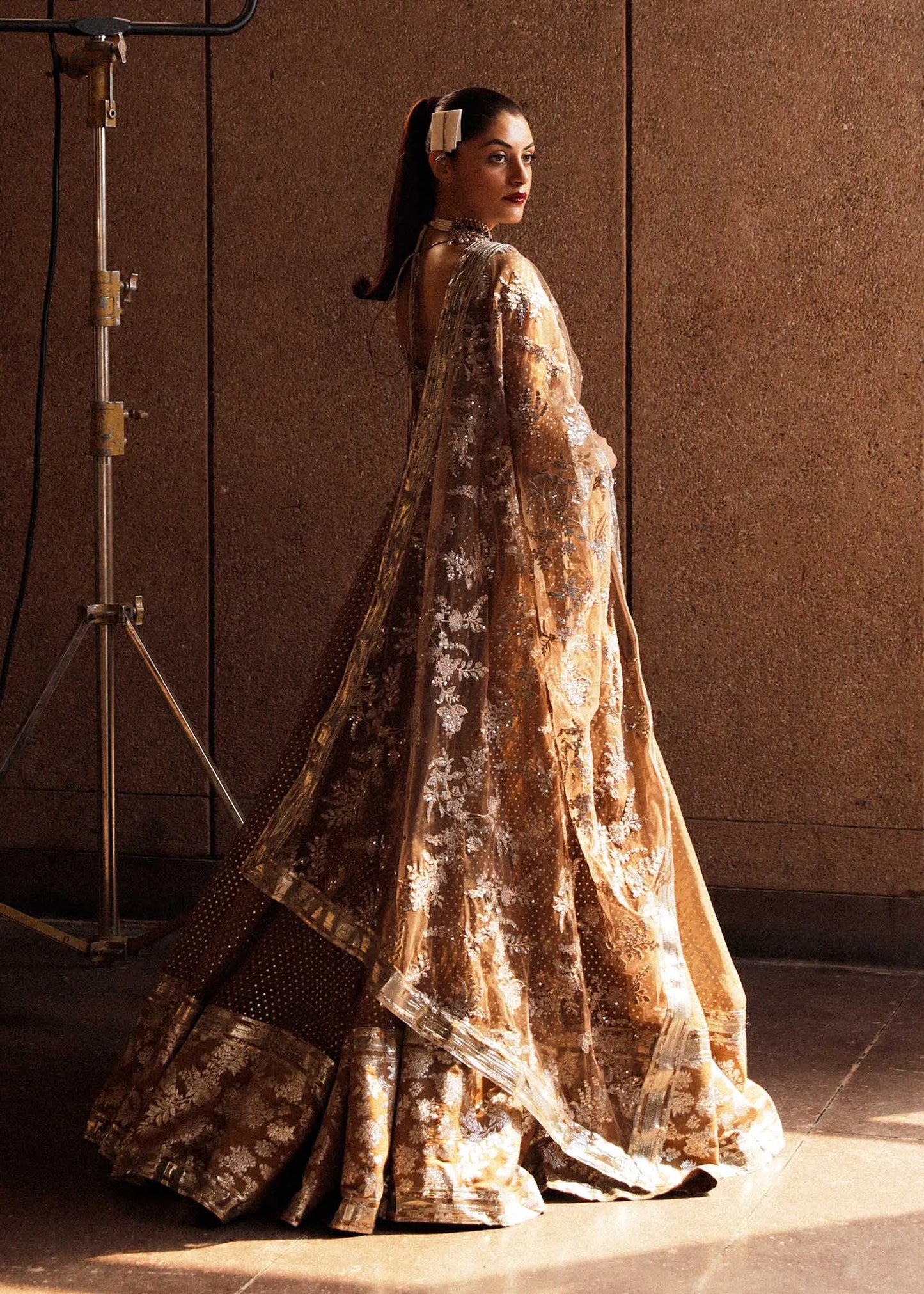 Woman in a long, patterned dress standing against a neutral background