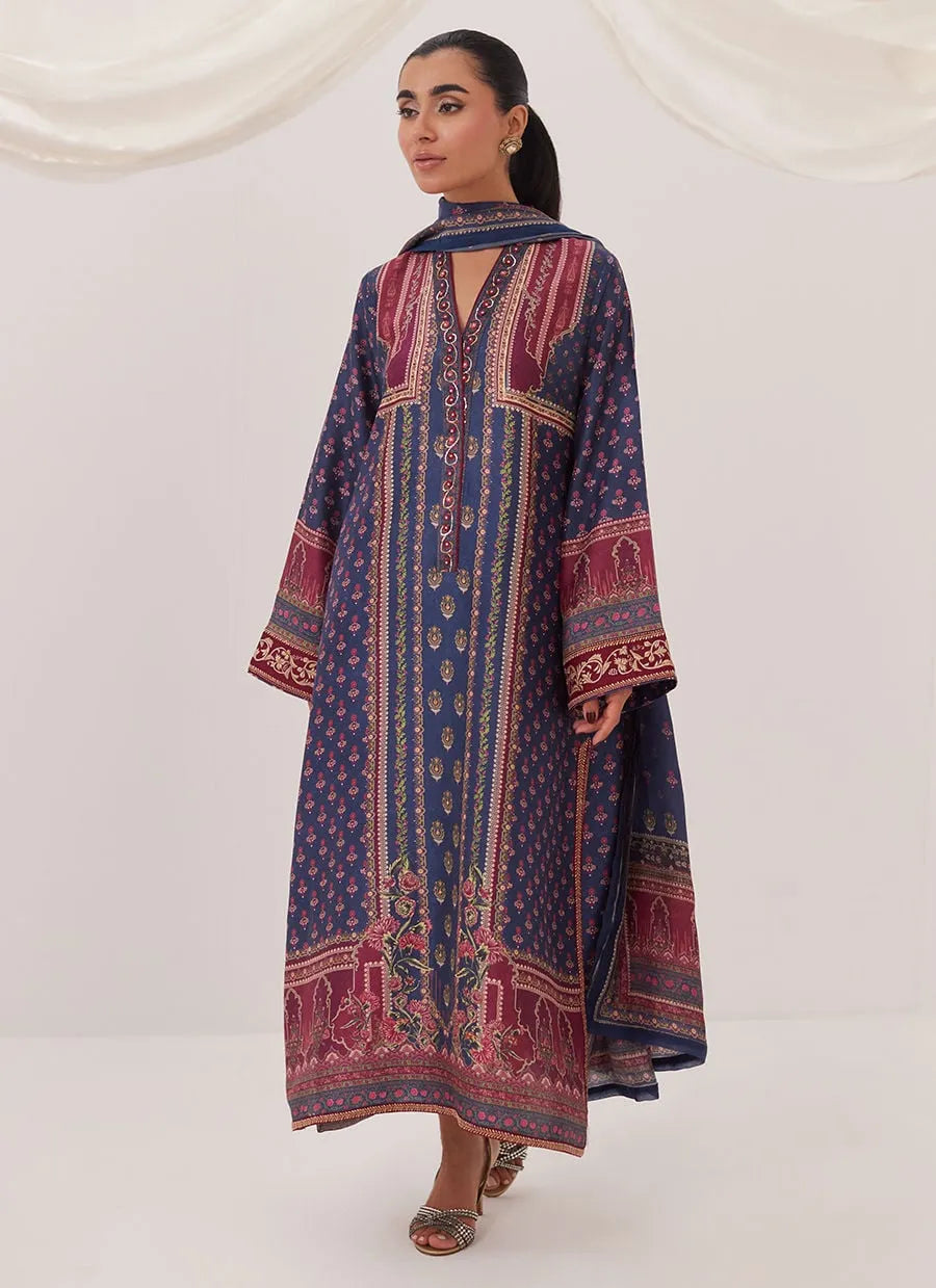 Woman wearing a long, patterned dress against a white background
