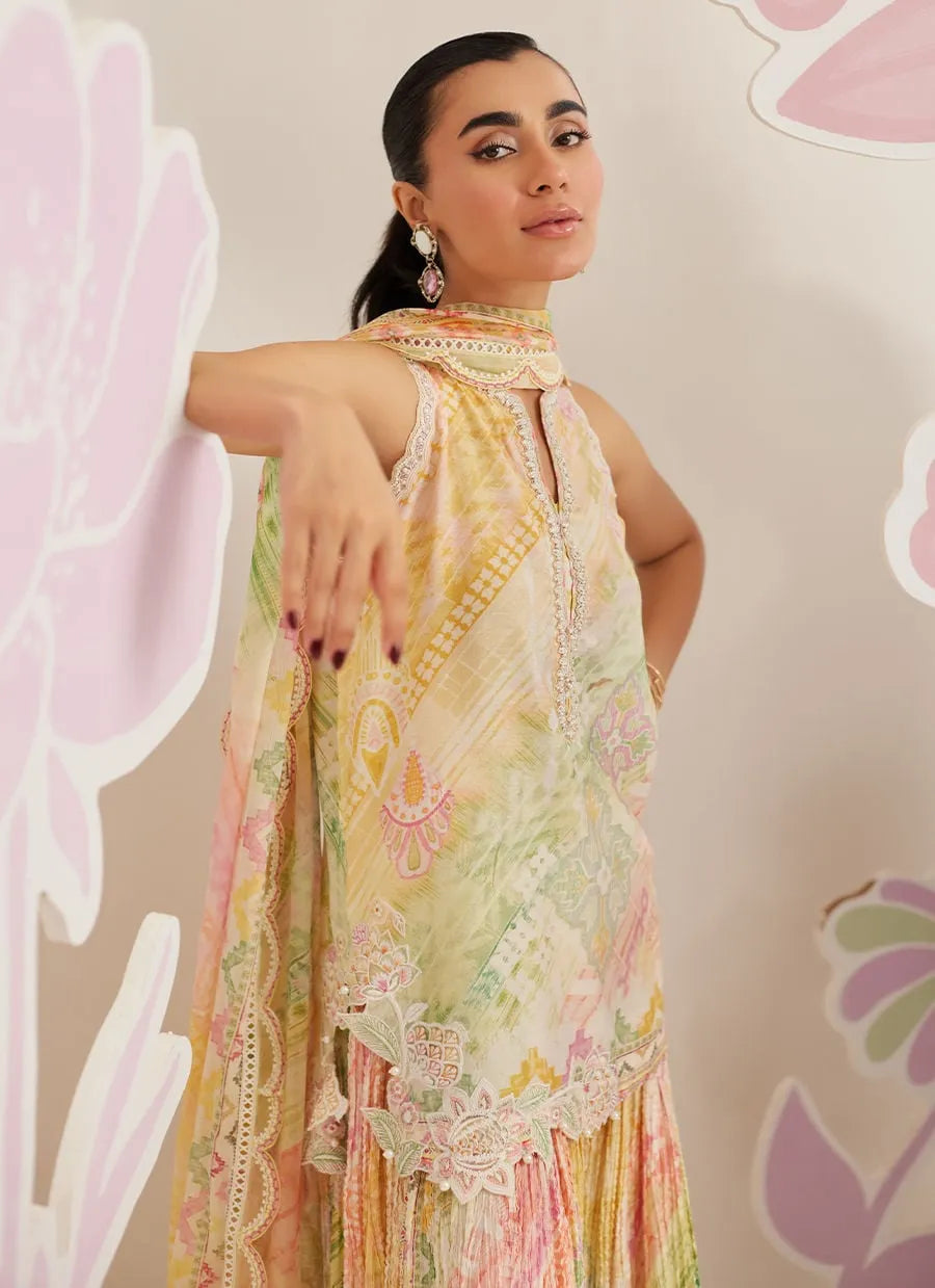 Woman wearing a colorful floral dress against a floral-patterned background