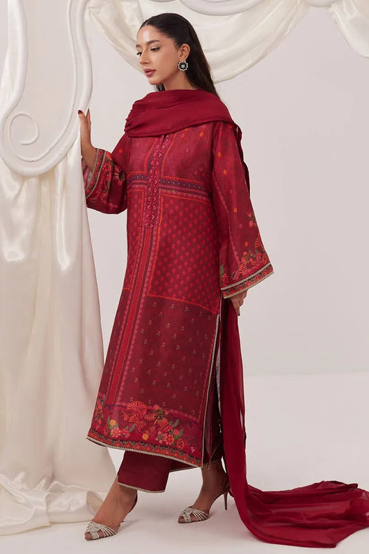 Woman wearing a red embroidered traditional outfit with a long scarf against a white background