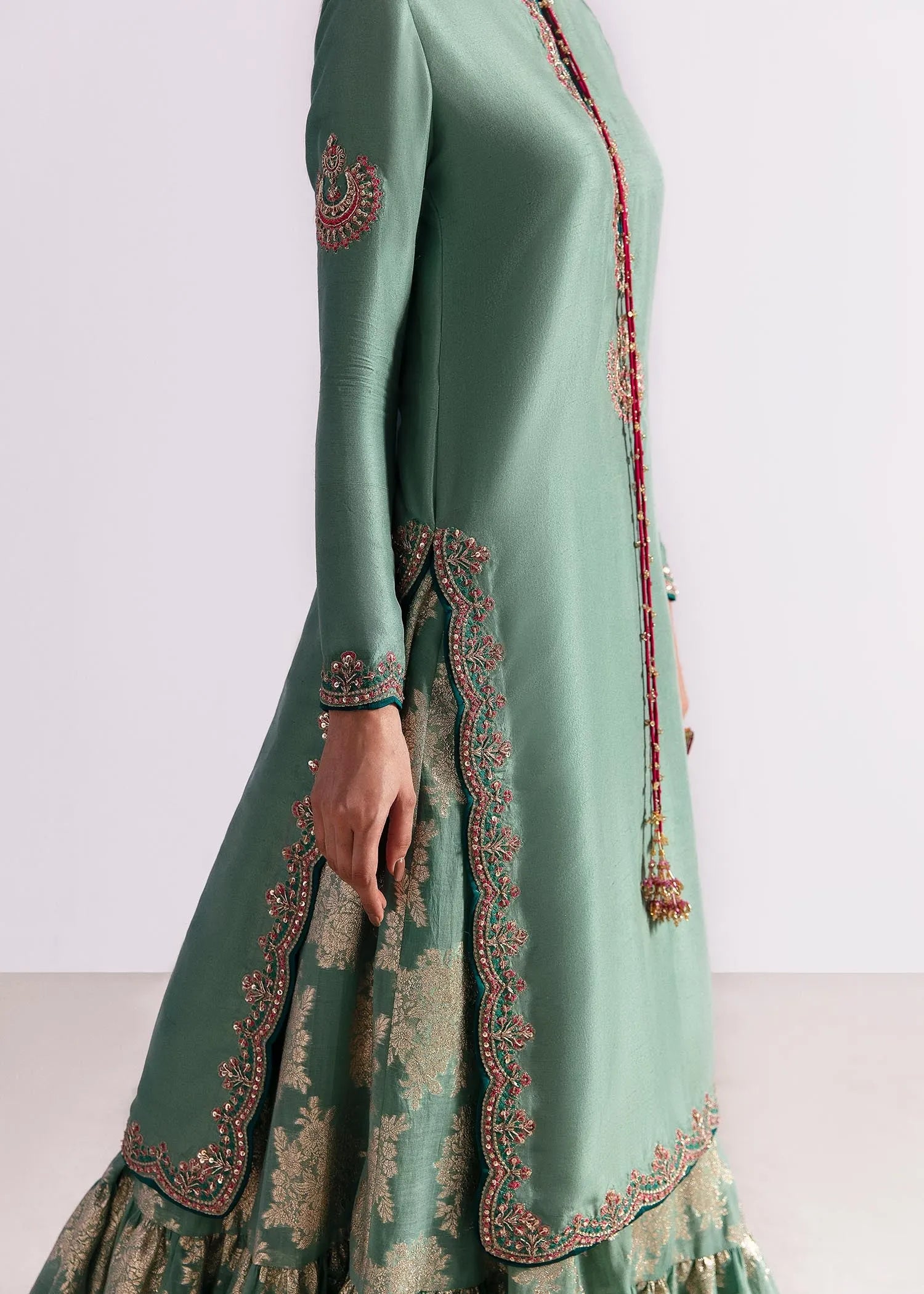 Green embroidered dress with intricate patterns on a white background