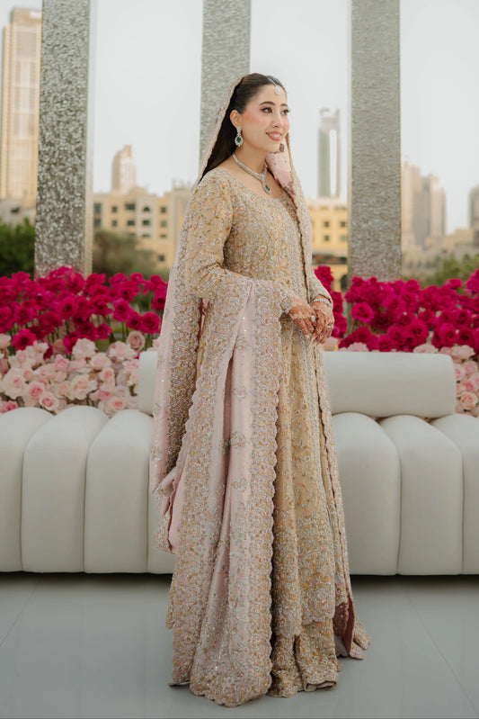 Woman in a floral dress standing in front of pink flowers and a cityscape.