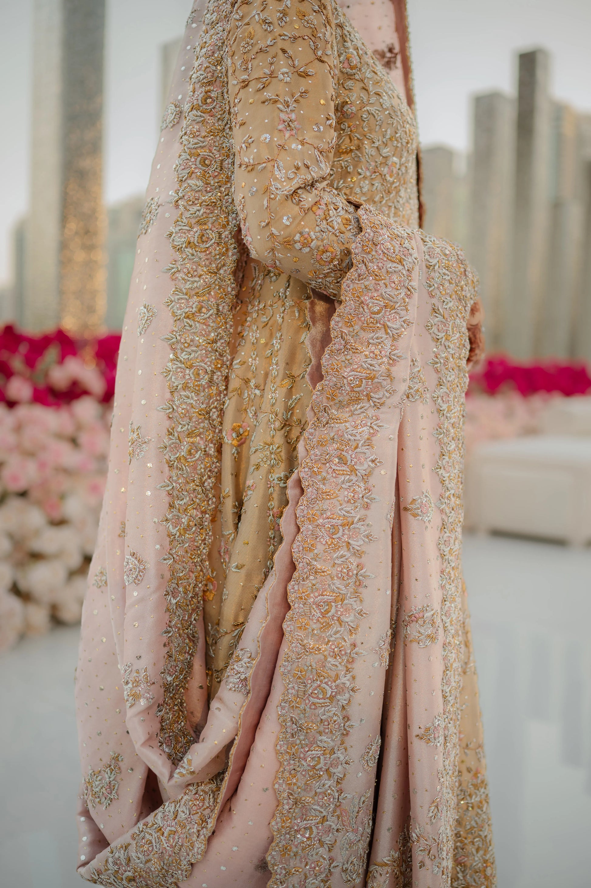 Close-up of a pink and gold embroidered fabric with a blurred background