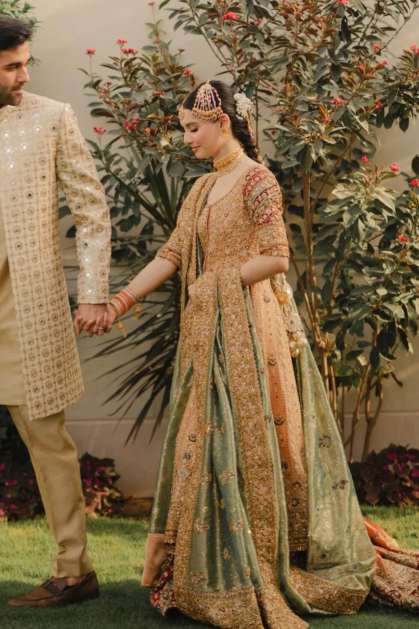 Couple holding hands with traditional attire in a garden setting