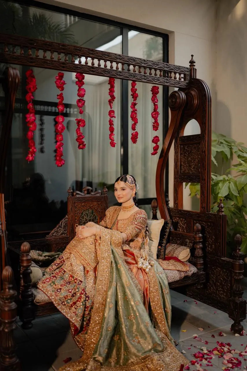 Woman in traditional attire sitting on an ornate wooden chair with decorative elements.