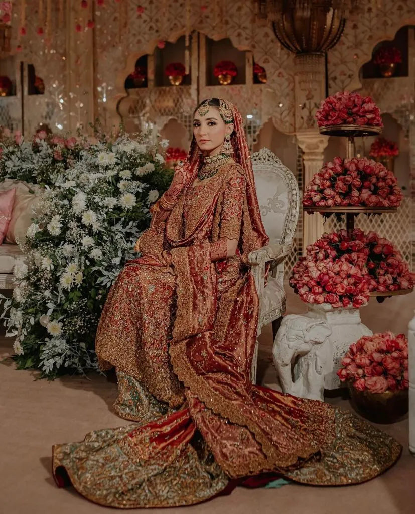 Woman in traditional attire sitting in a decorated room with flowers