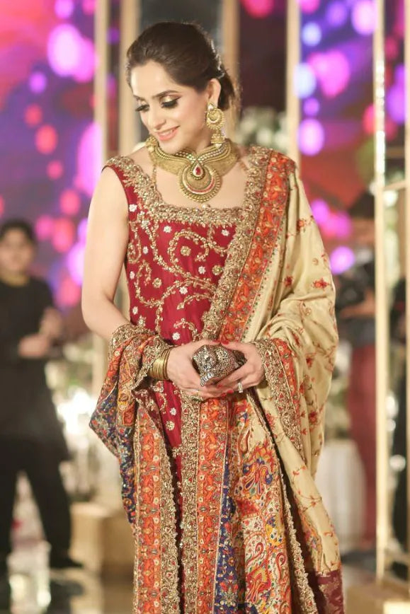 Woman in traditional embroidered outfit with vibrant colors against a blurred background