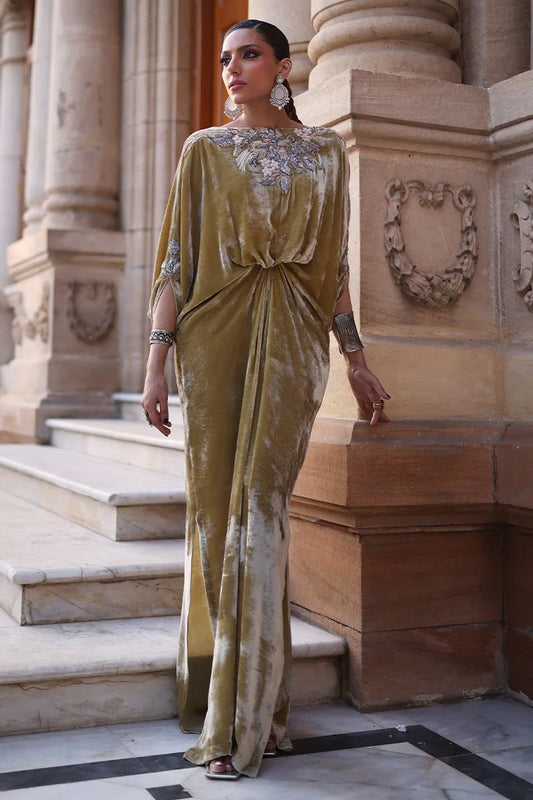 Woman in a long, elegant dress standing on steps with classical architecture in the background