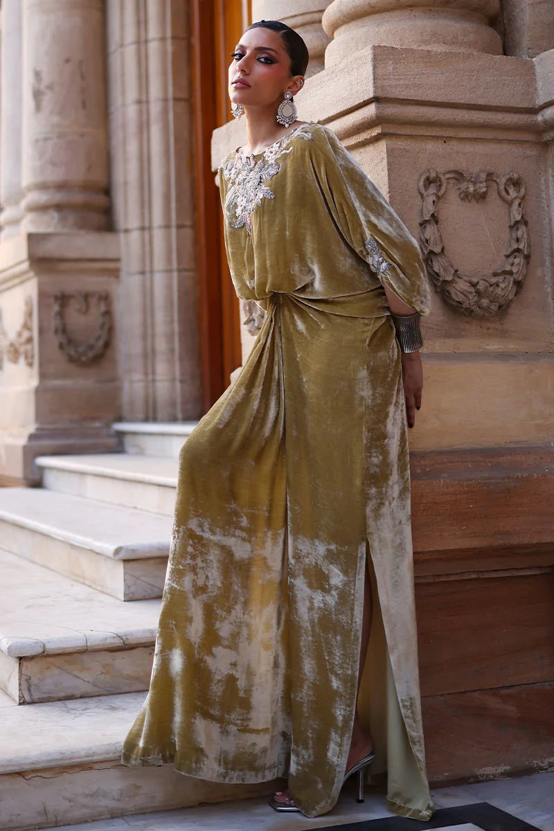 Woman in a gold and white dress standing in front of a classical building.