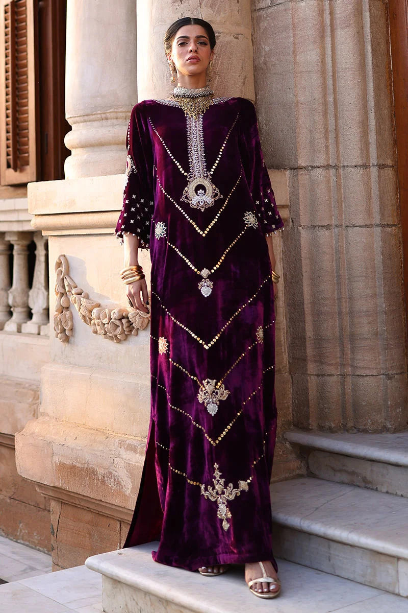 Woman in an ornate purple dress standing on steps with classical architecture in the background