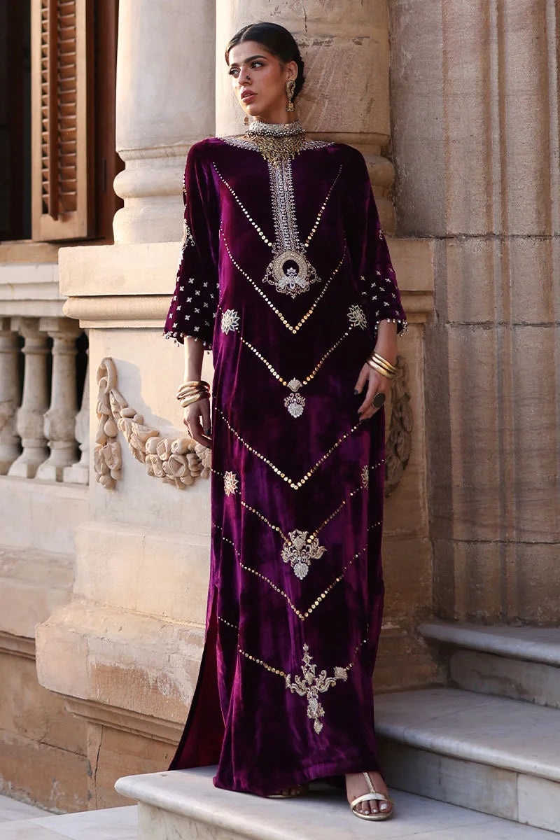 Woman in an ornate purple dress standing on steps with classical architecture in the background
