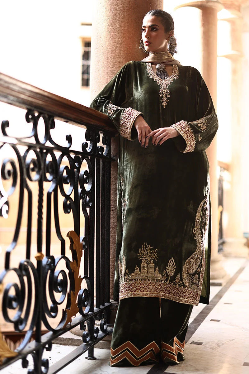 Woman in a black and gold traditional outfit standing on a balcony.