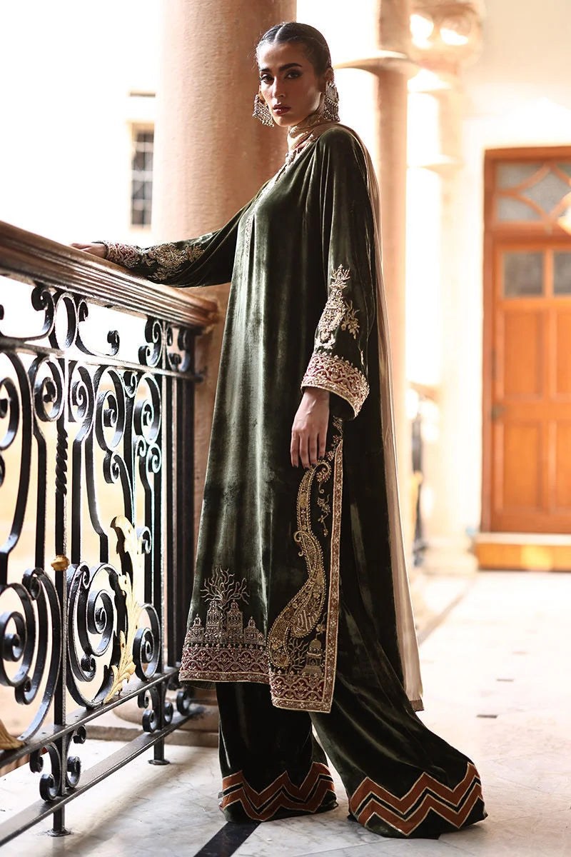 Woman in a traditional outfit with intricate designs standing on a balcony.