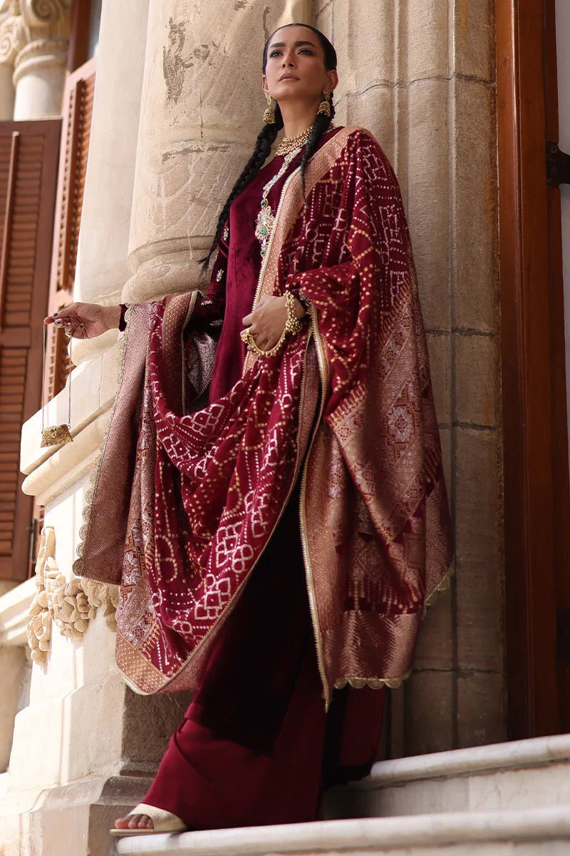 Woman in traditional attire standing on steps with architectural background
