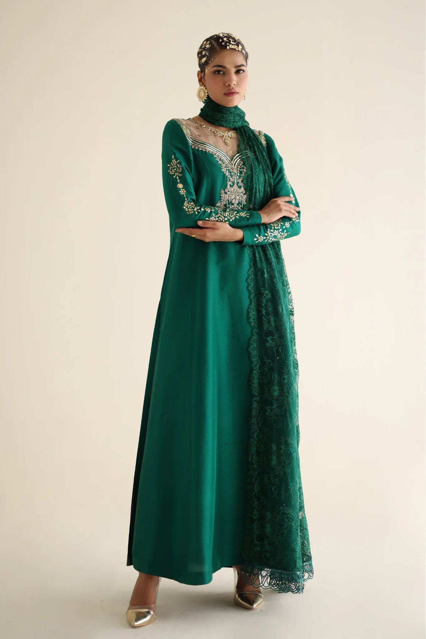 Woman wearing a green embroidered dress on a beige background