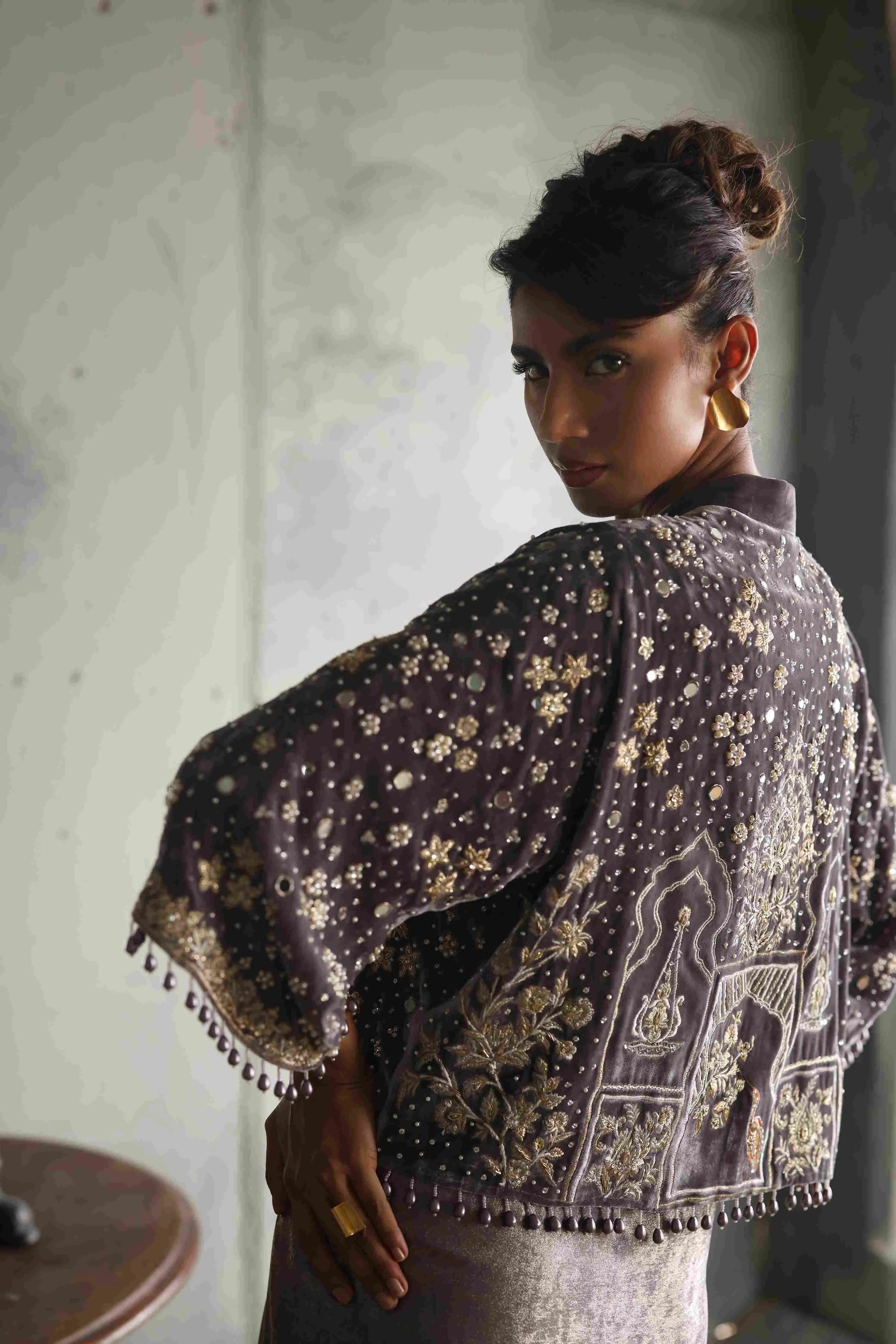 Woman wearing a patterned shawl in an indoor setting
