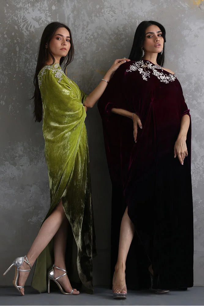 Two women wearing elegant dresses against a gray background