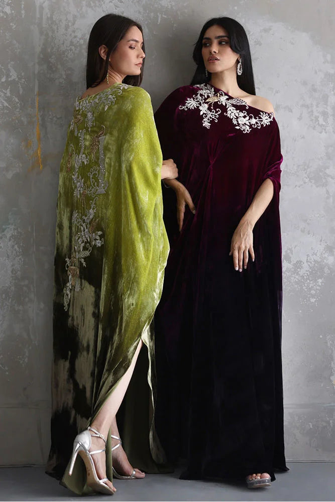 Two women wearing elegant dresses with floral patterns against a gray background