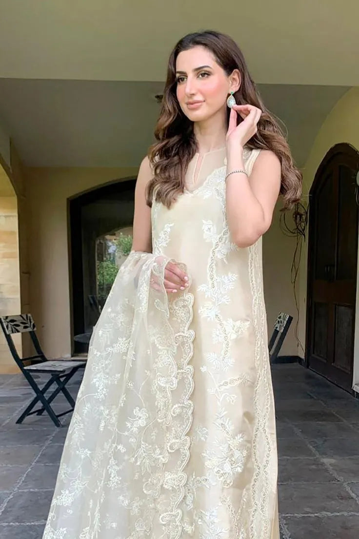 Woman in a white floral dress standing outdoors.