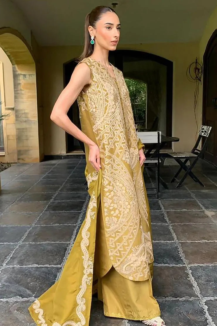 Woman in a yellow traditional outfit standing on a stone patio.