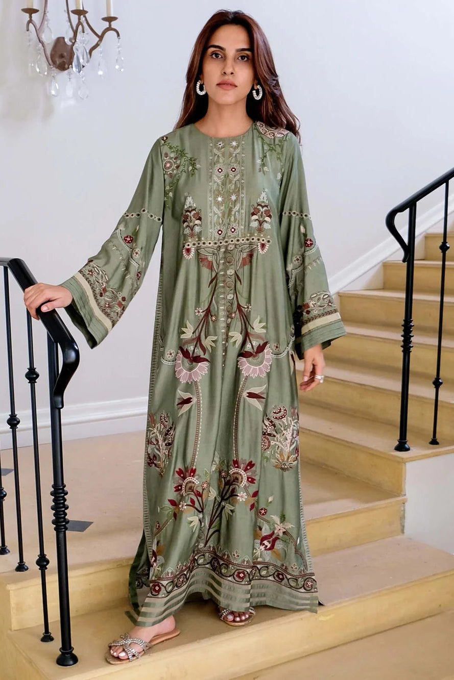 Woman in a green embroidered dress standing on a staircase