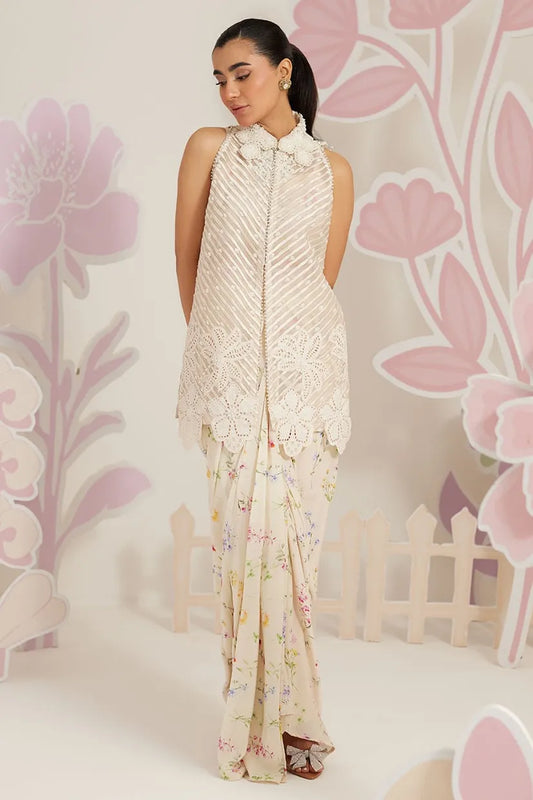 Woman wearing a cream-colored dress with floral patterns against a floral background
