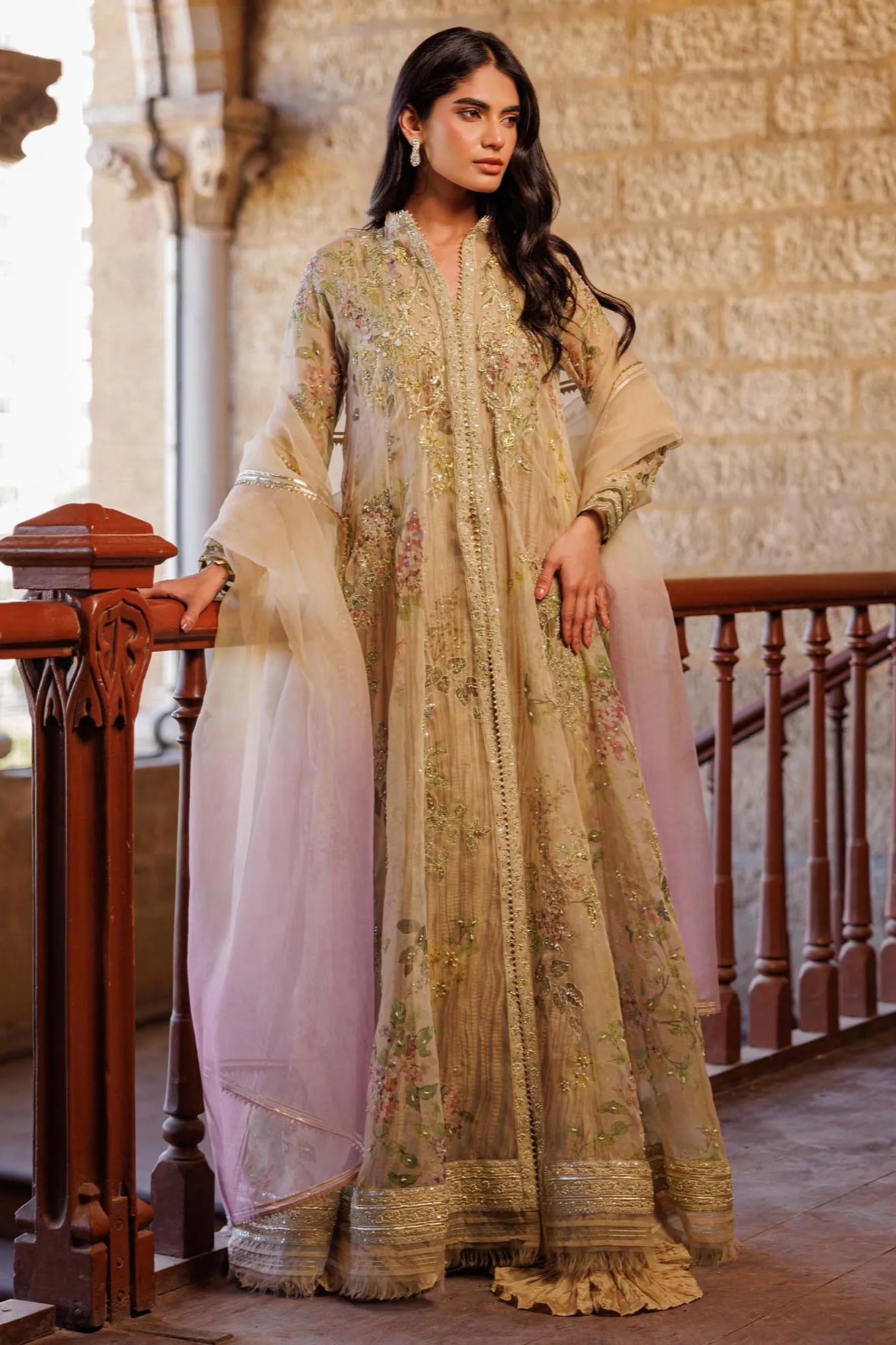 Woman in a traditional outfit standing in an elegant interior setting.
