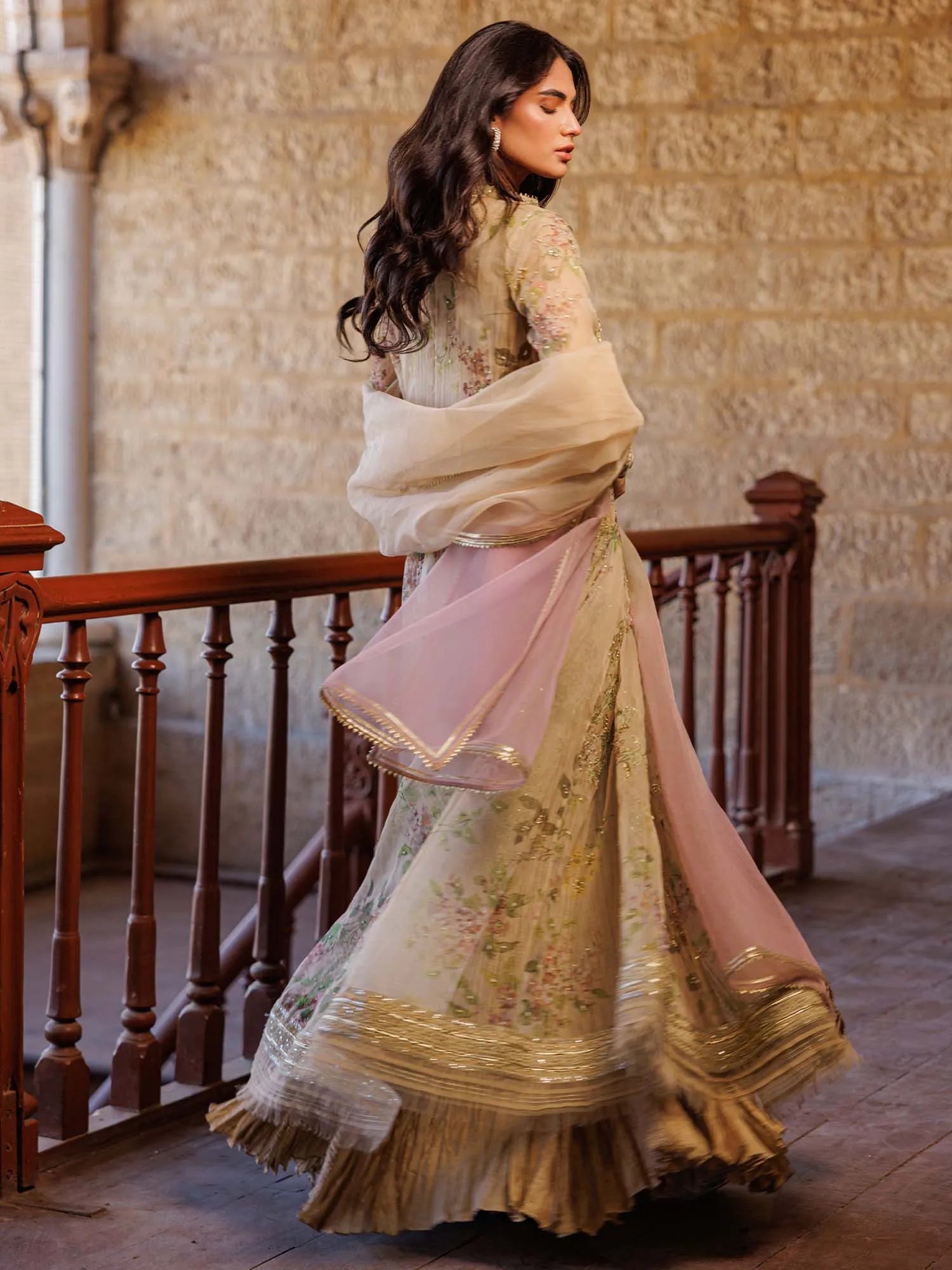 Woman in traditional outfit with floral design in a historic setting