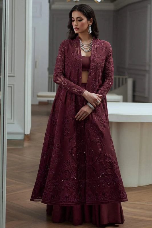 Woman wearing a burgundy embroidered dress and jacket in an indoor setting.