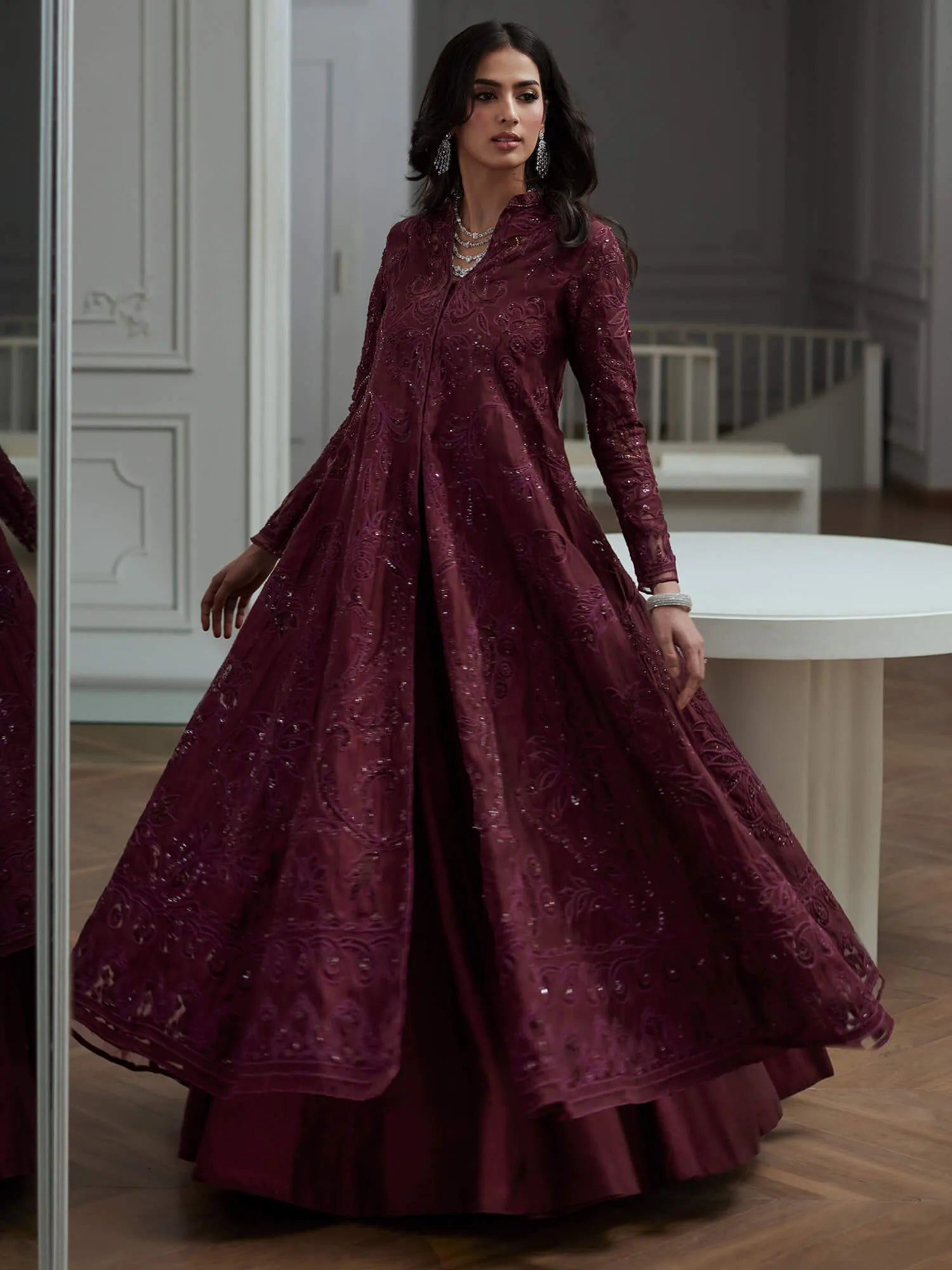 Woman wearing a burgundy embroidered dress in an elegant interior setting