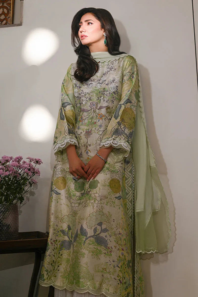 Woman wearing a green floral dress with a sheer dupatta, standing against a plain background.