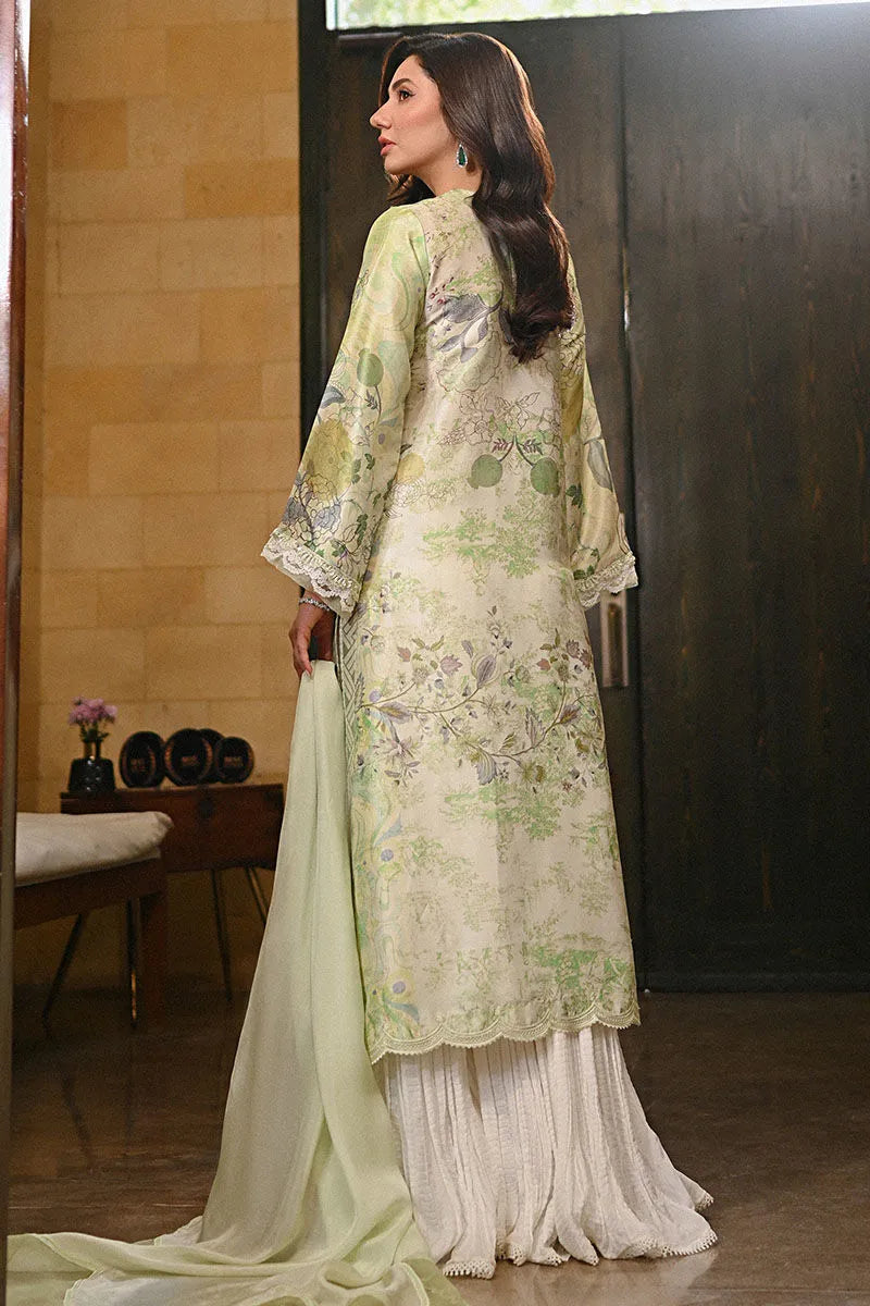 Woman wearing a light green embroidered traditional outfit in an indoor setting.