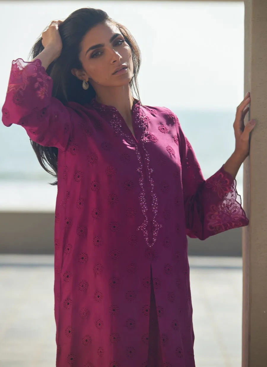 Woman wearing a pink embroidered traditional outfit with a blurred background