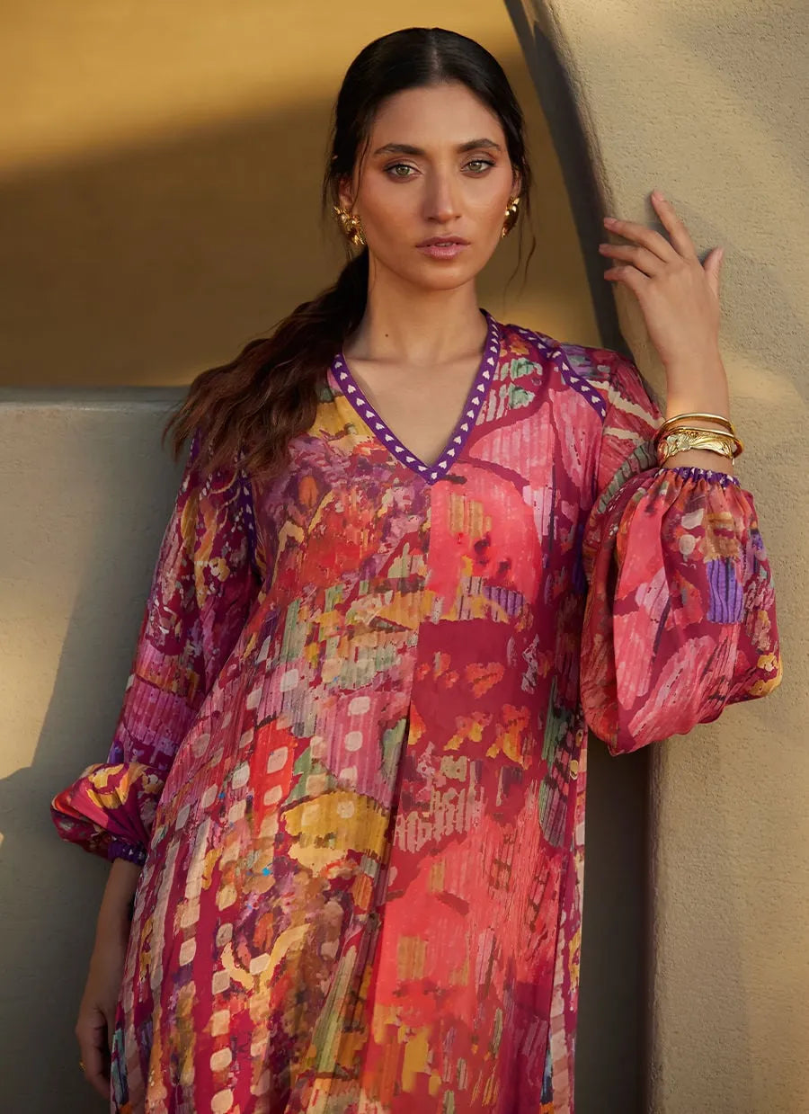 Woman wearing a colorful patterned dress against a neutral background