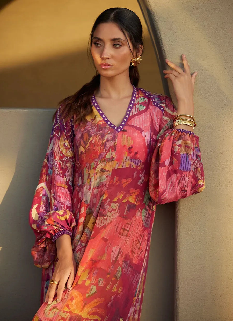 Woman wearing a colorful patterned dress against a neutral background