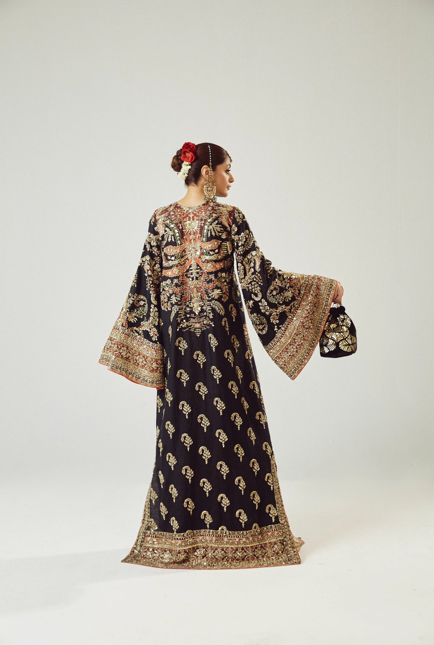 Woman wearing a traditional embroidered outfit on a white background