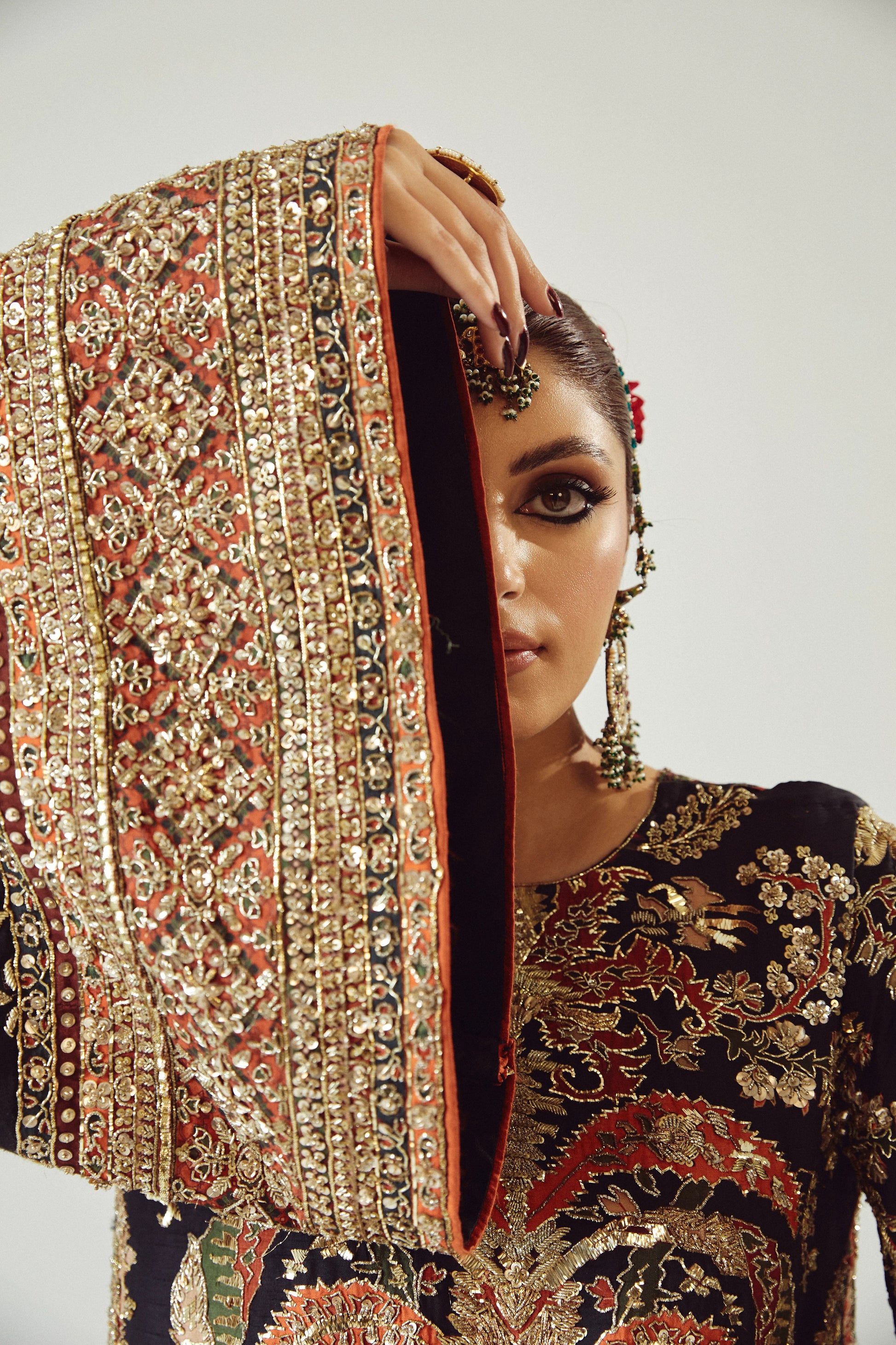 Woman wearing a traditional embroidered outfit with a focus on intricate patterns.