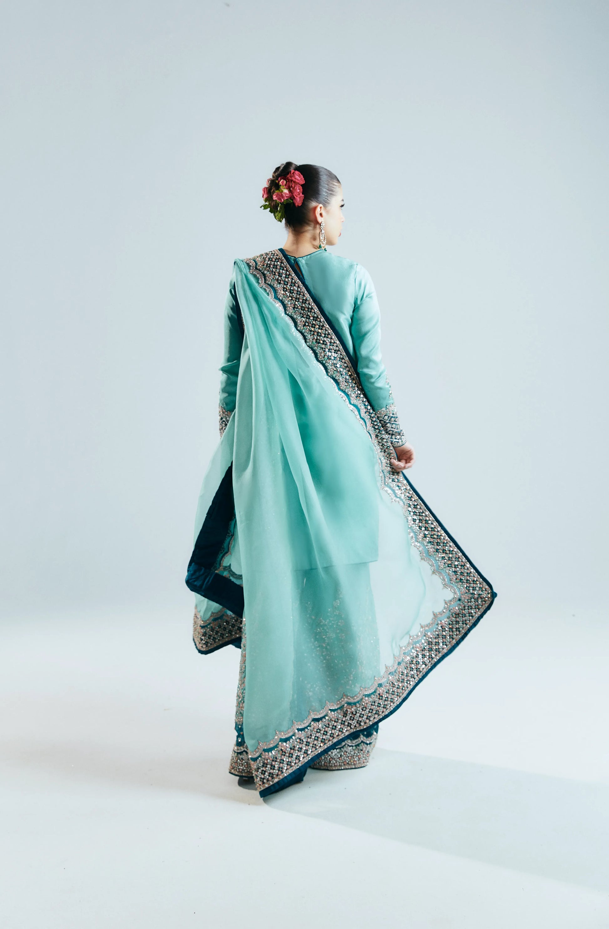 Woman wearing a light blue saree with a white background