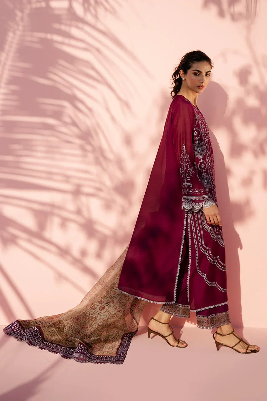 Woman in a maroon embroidered outfit with a matching dupatta against a pink background