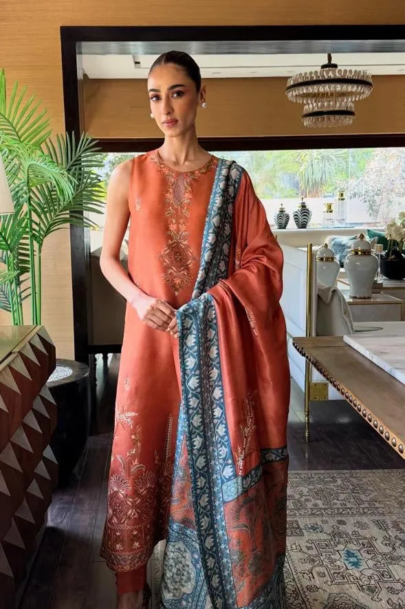 Woman in a peach-colored traditional outfit with a blue dupatta in a decorated room.