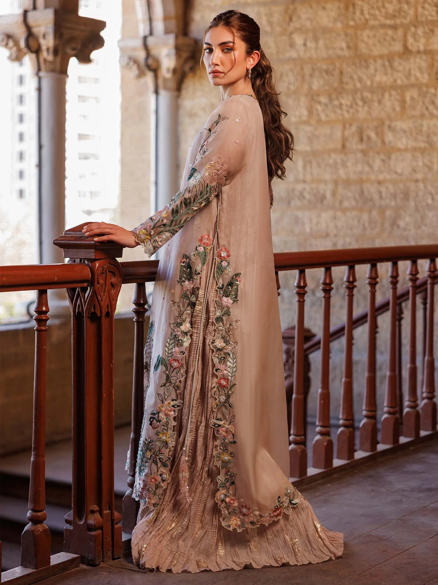 Woman in a floral dress standing in an elegant interior setting