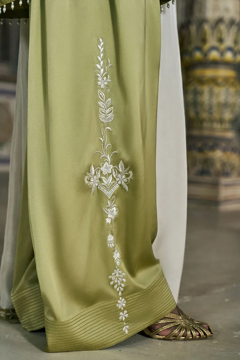 Green dress with white floral embroidery on a blurred background