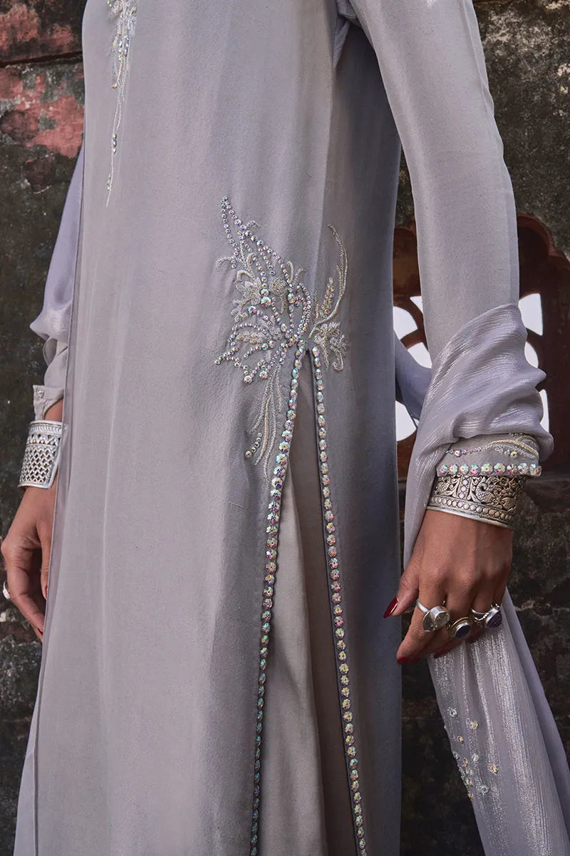 Gray dress with intricate beadwork on a textured background